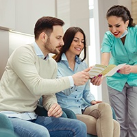 Couple looking at financing options with dental staff member